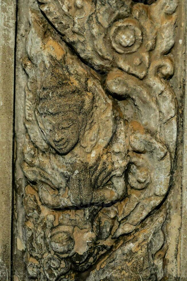 a carving of a buddha on a wall photo