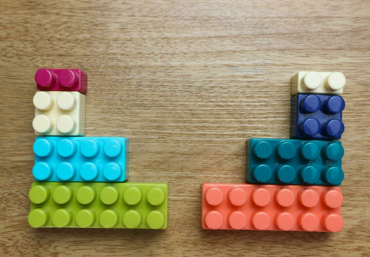 Plastic building blocks on wooden background photo