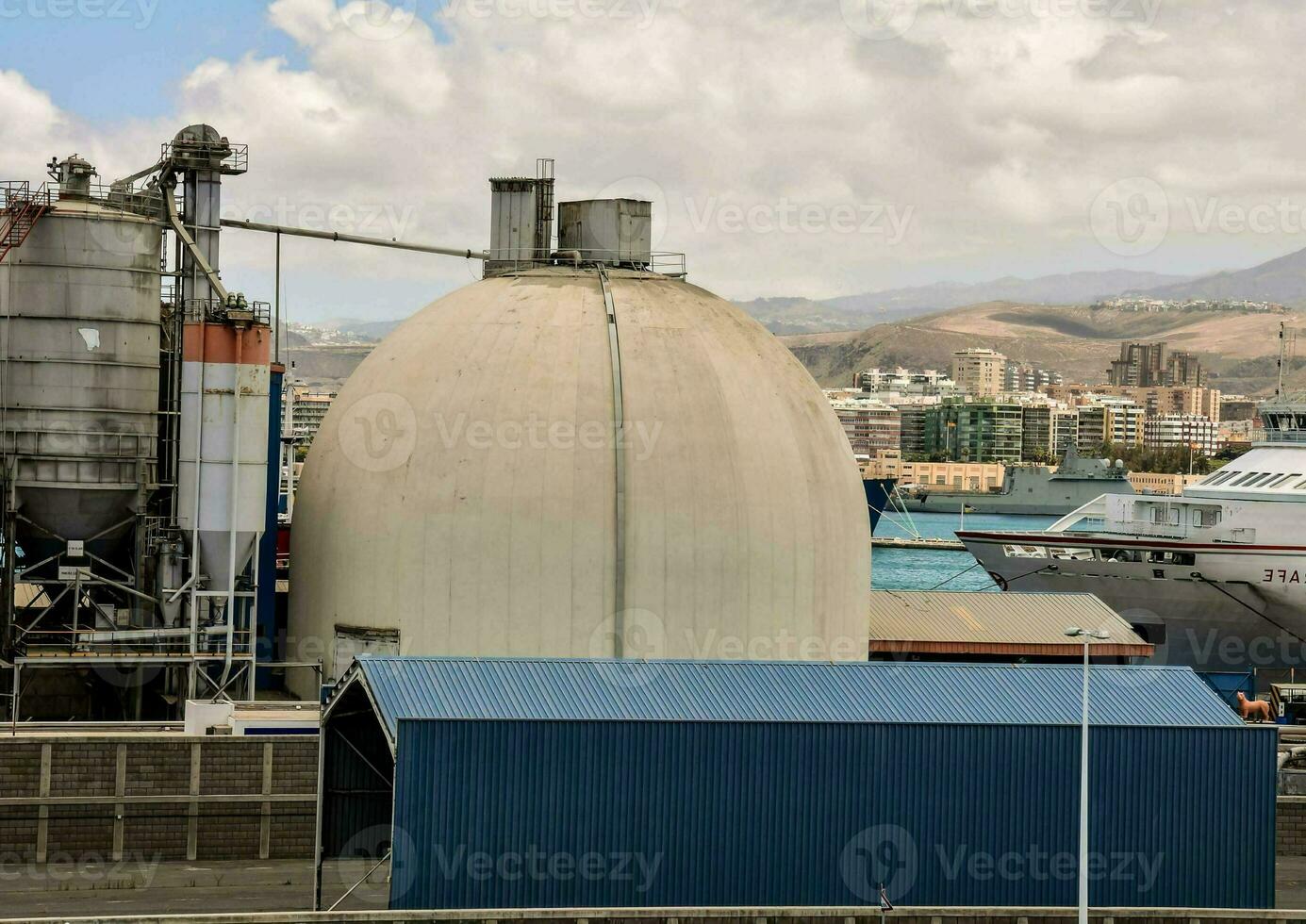 a large industrial building with a ship in the background photo