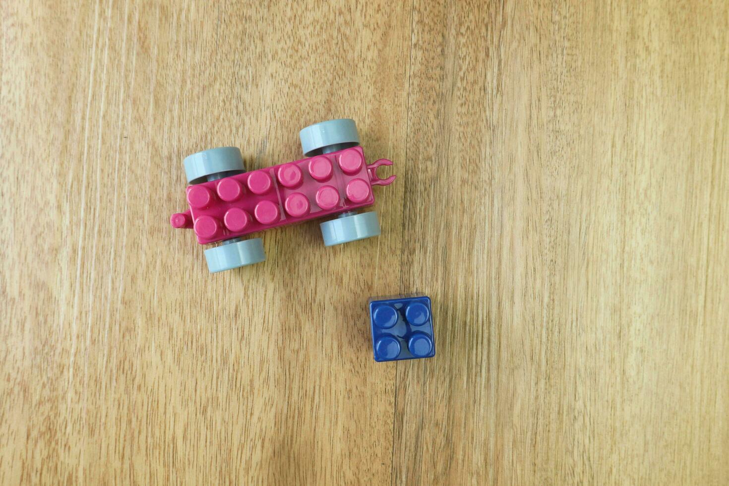Top view of plastic building blocks on wooden background photo