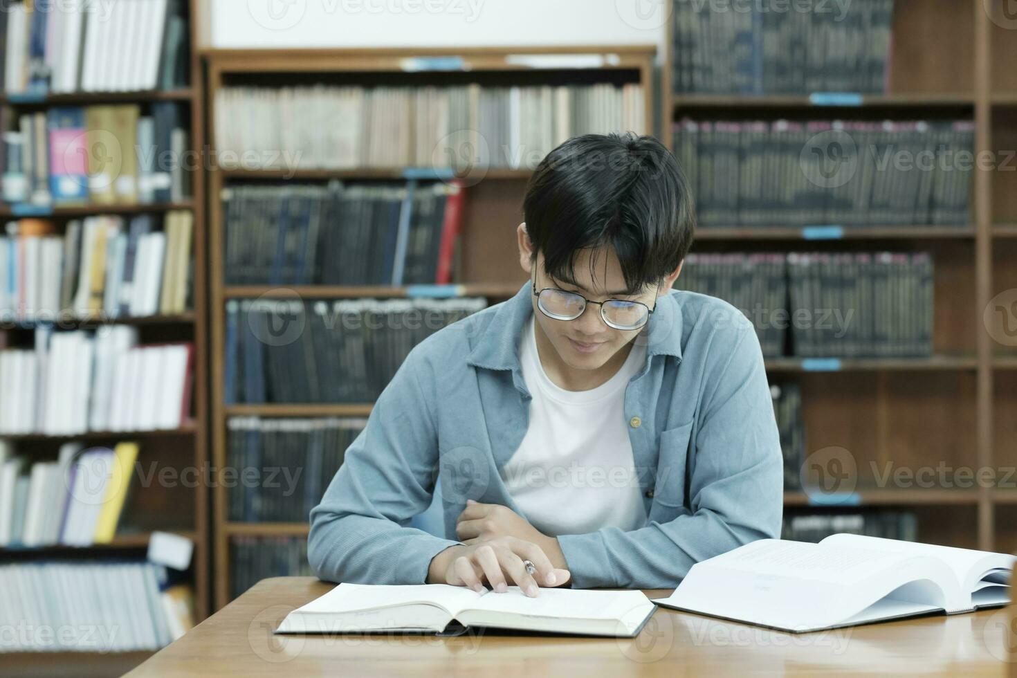 University students reading books in library for research. photo