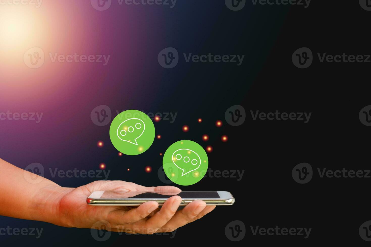 Business and technology concept. Hand-holding smartphone or mobile phone with a green icon of the chat box on blue background. Communication online with the internet. photo