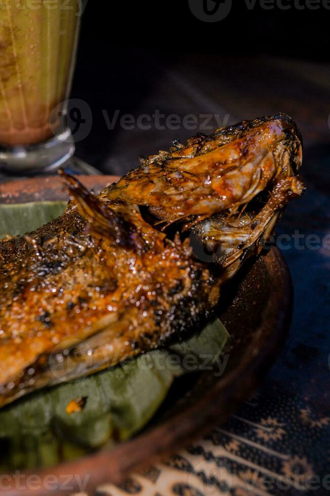 Tasty grilled fish on kitchen table photo
