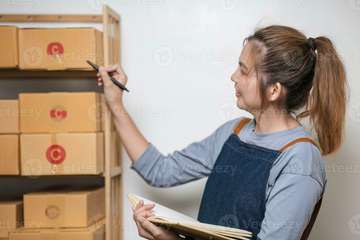 Portrait business woman smile and use tablet checking information on parcel shipping box before send to customer. Entrepreneur small business working at home. SME business online marketing. photo