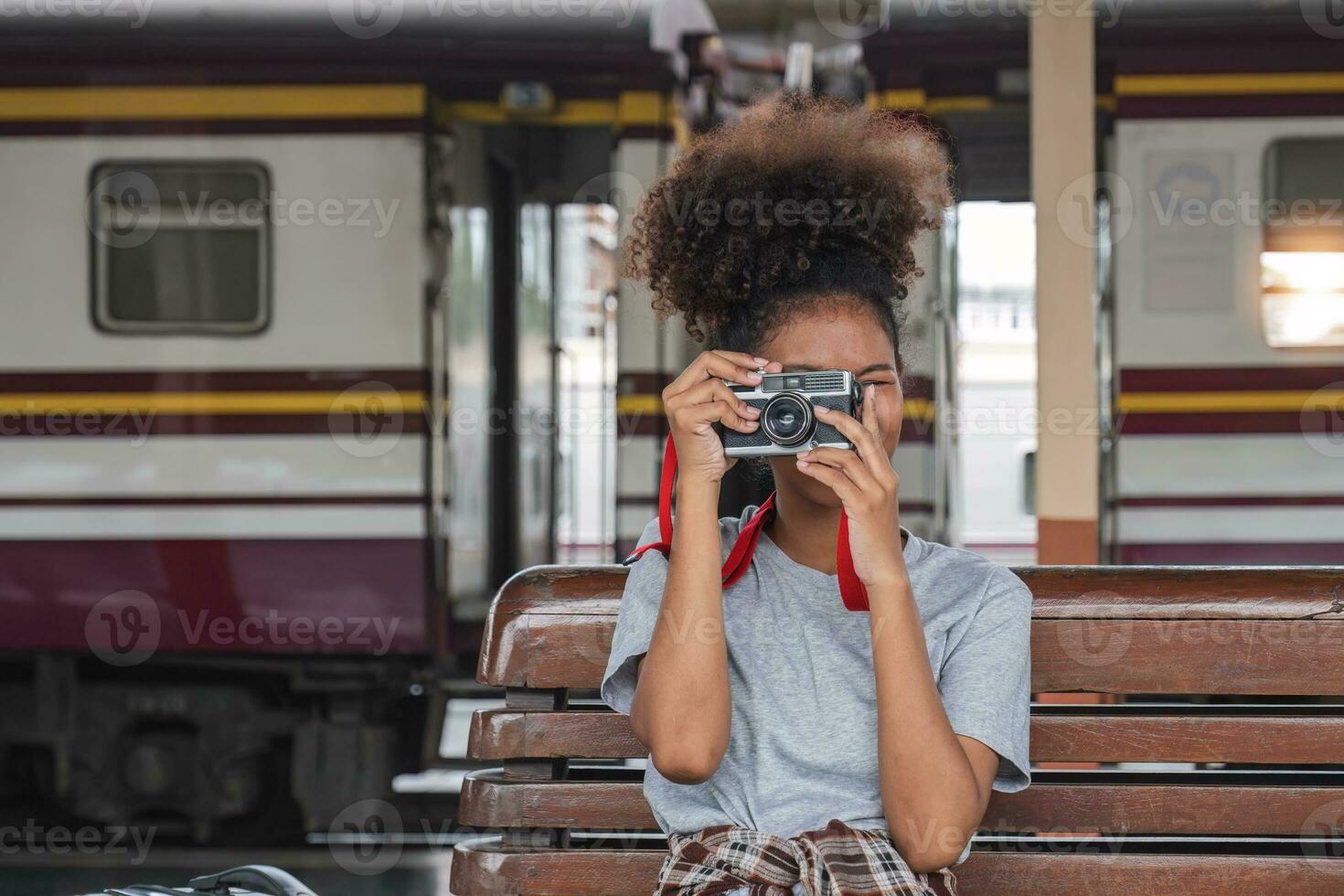 joven asiático africano mujer viajero con mochila en el ferrocarril tren estación, viajero niña caminando estar sentar esperando tomar un imagen en ferrocarril plataforma tren estación. alto calidad foto