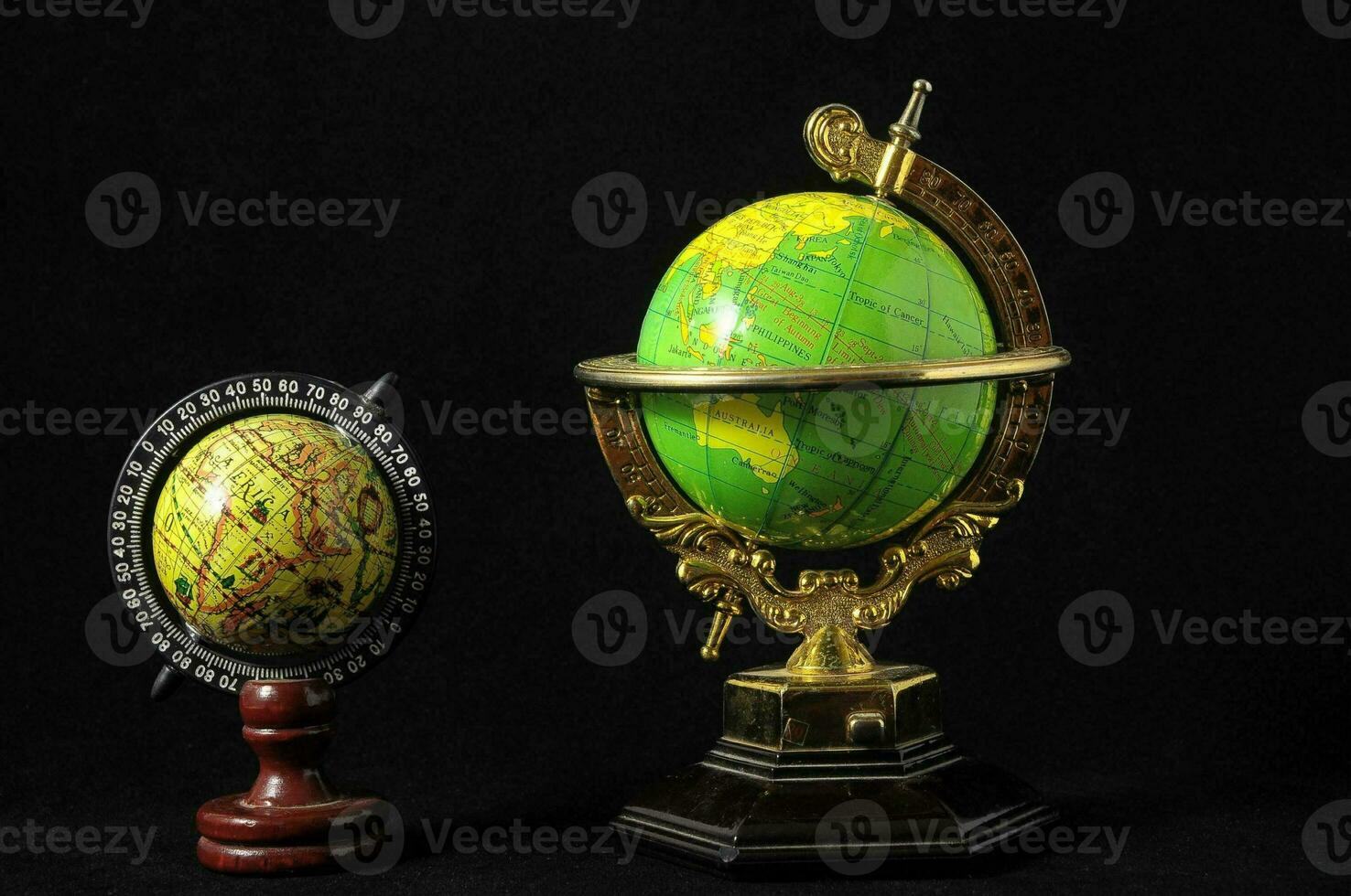 two antique globe models on a black background photo