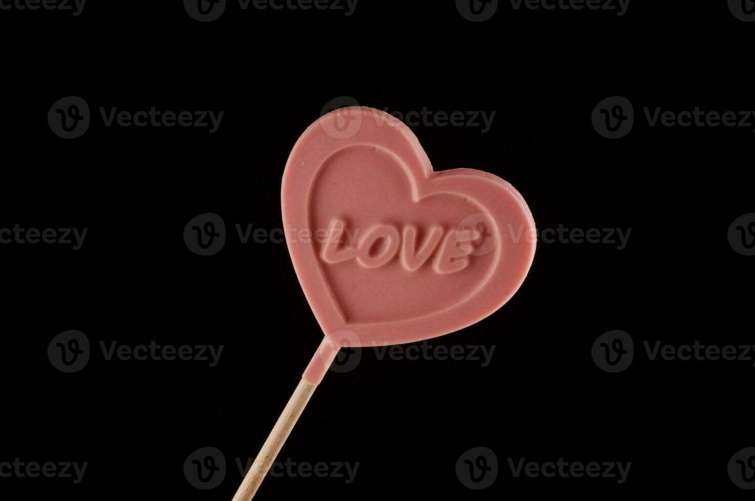 a pink heart shaped lollipop with the word love written on it photo