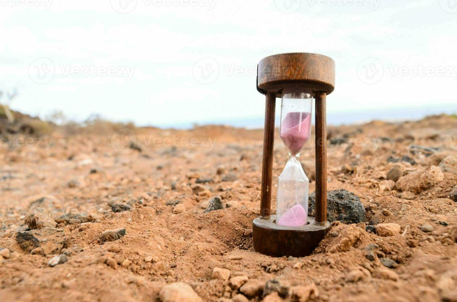 an hourglass sitting on the ground in a desert photo