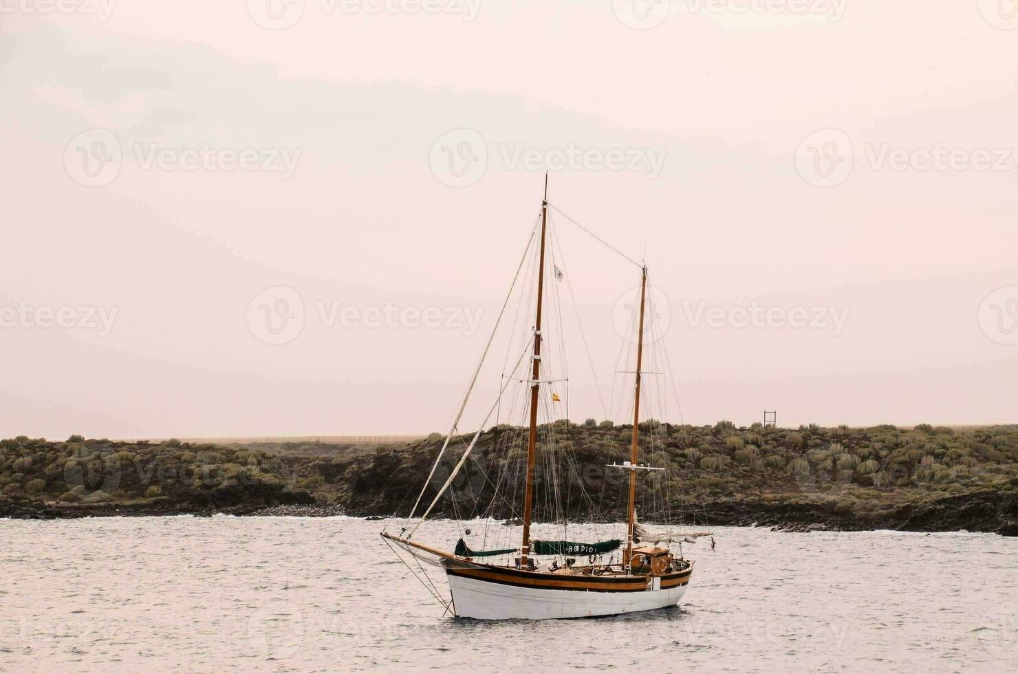 a sailboat in the ocean at sunset photo