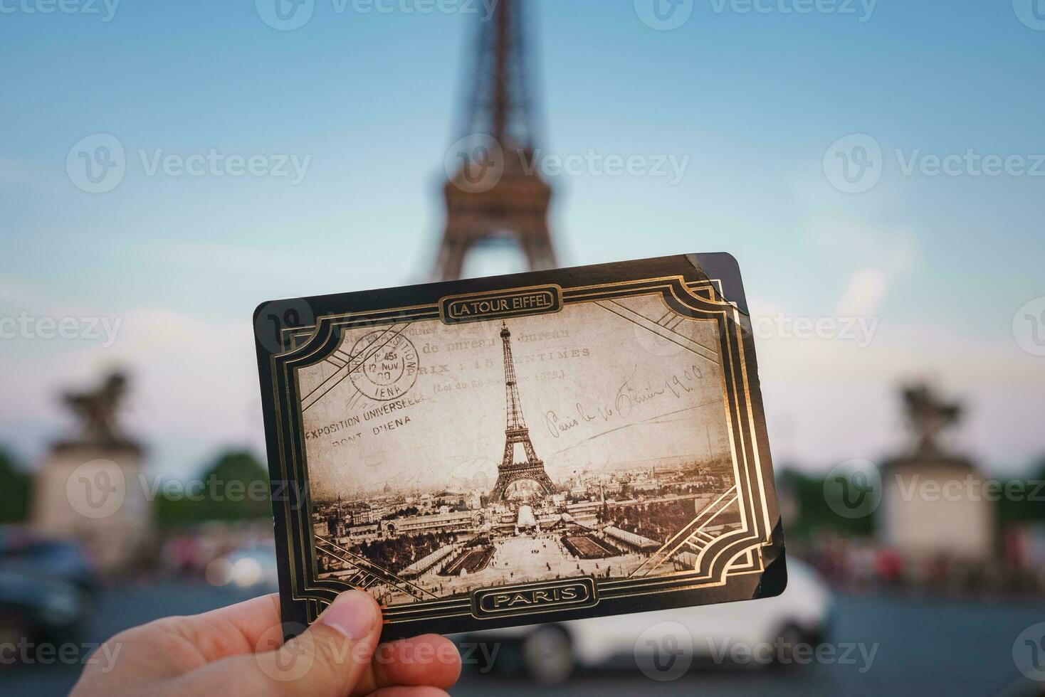 Man Holding Eiffel Tower Postcard with Eiffel Tower Background photo