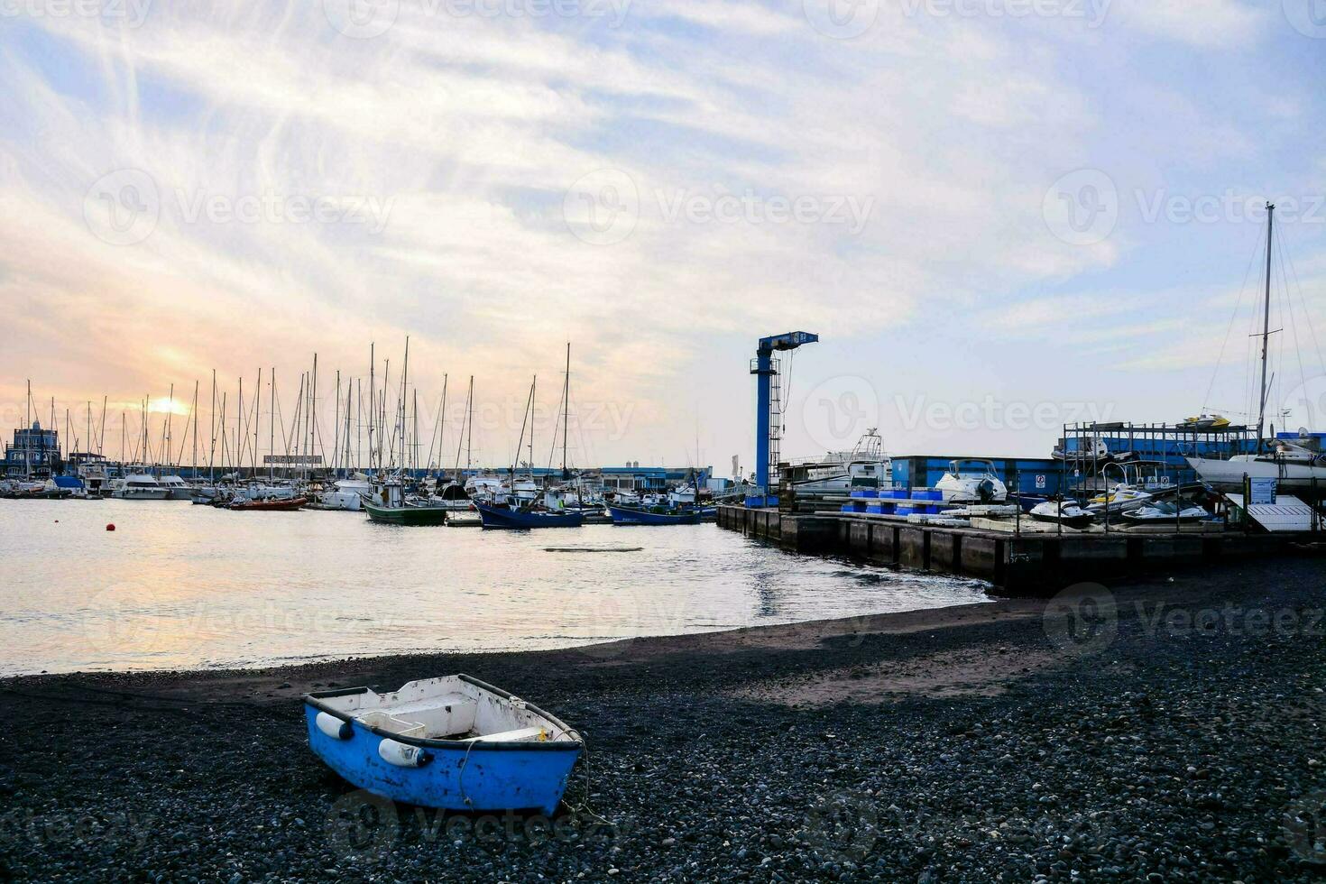 boats are docked at the beach at sunset photo