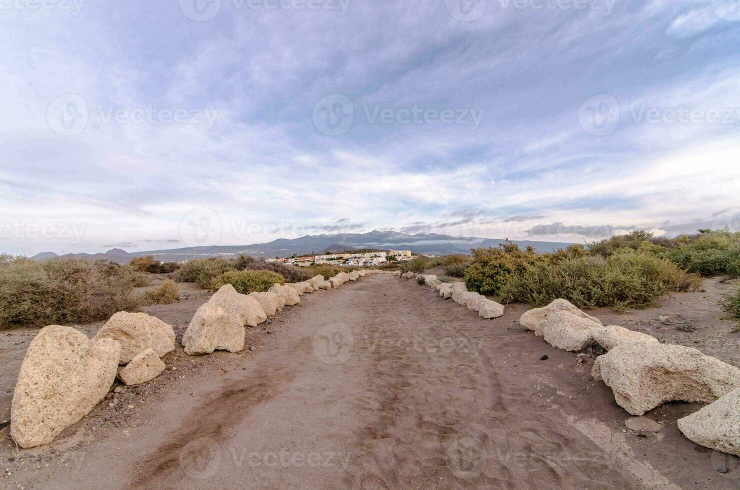a path in the desert with rocks and dirt photo