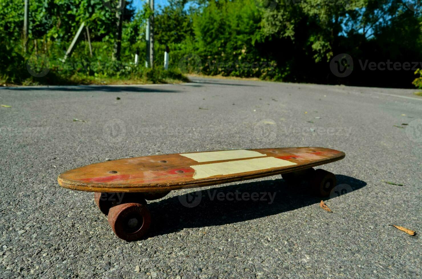 a skateboard with a wooden deck on the road photo