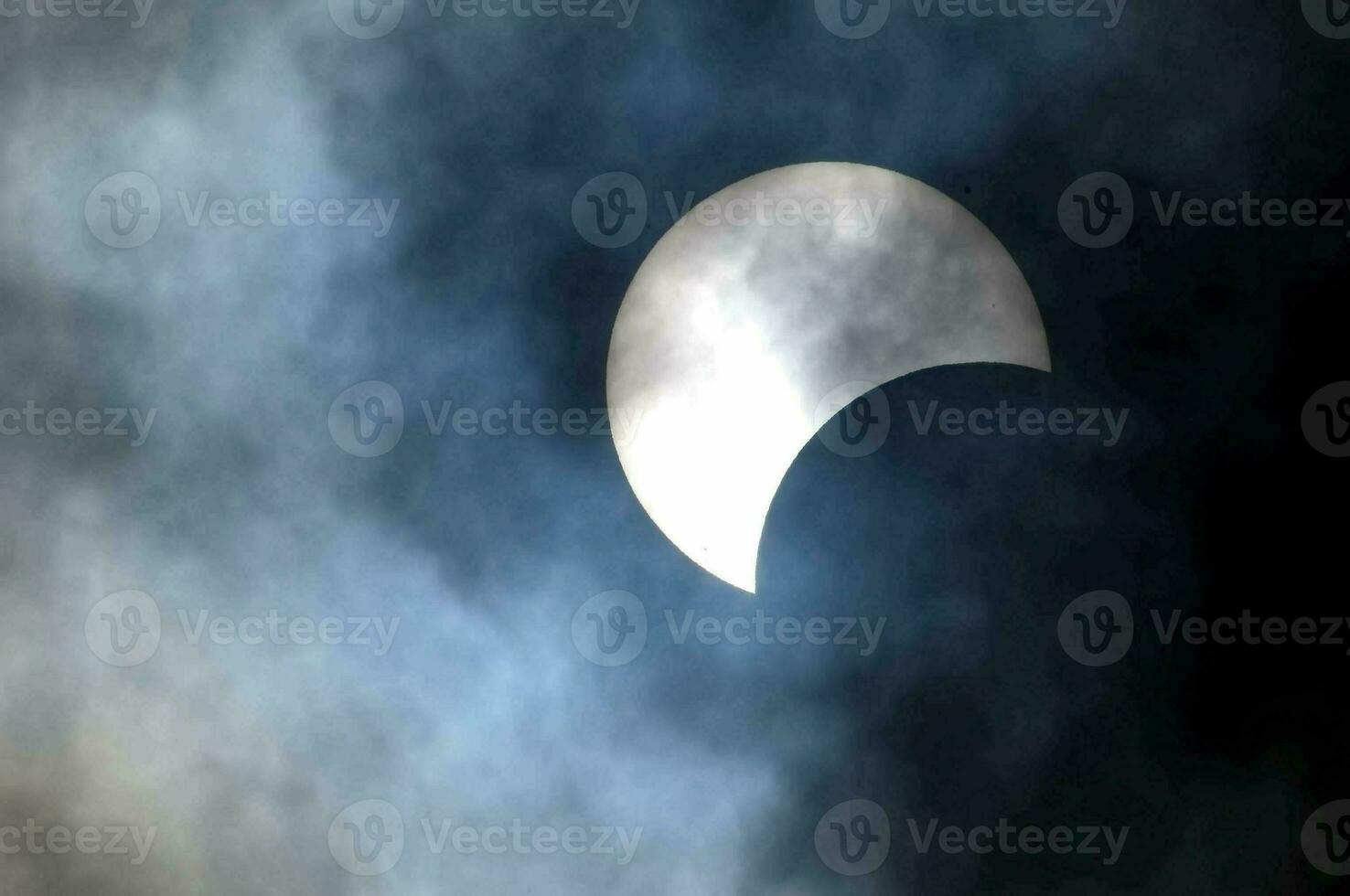 the moon during a partial solar eclipse in the sky photo