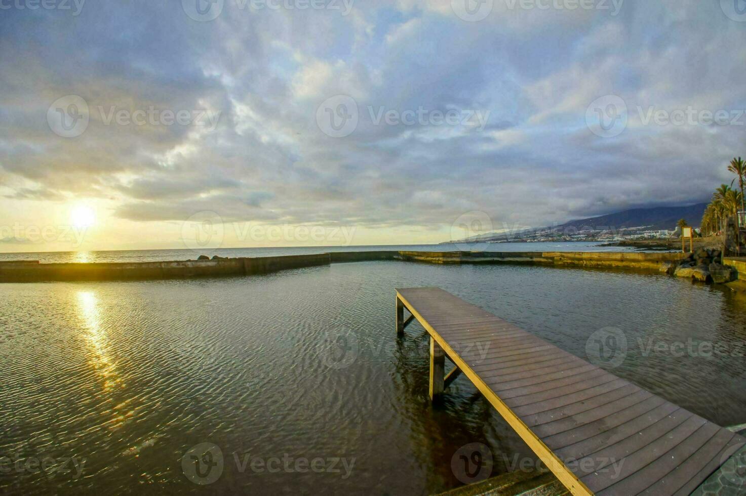 un muelle en el agua a puesta de sol foto