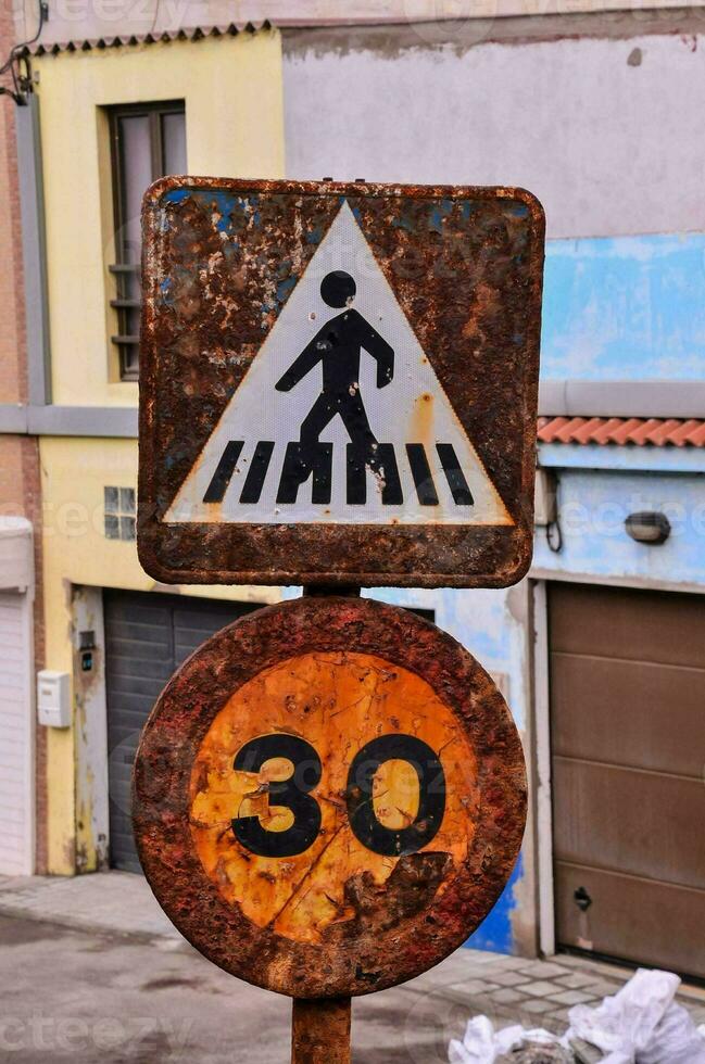a rusty sign with a man walking on it photo
