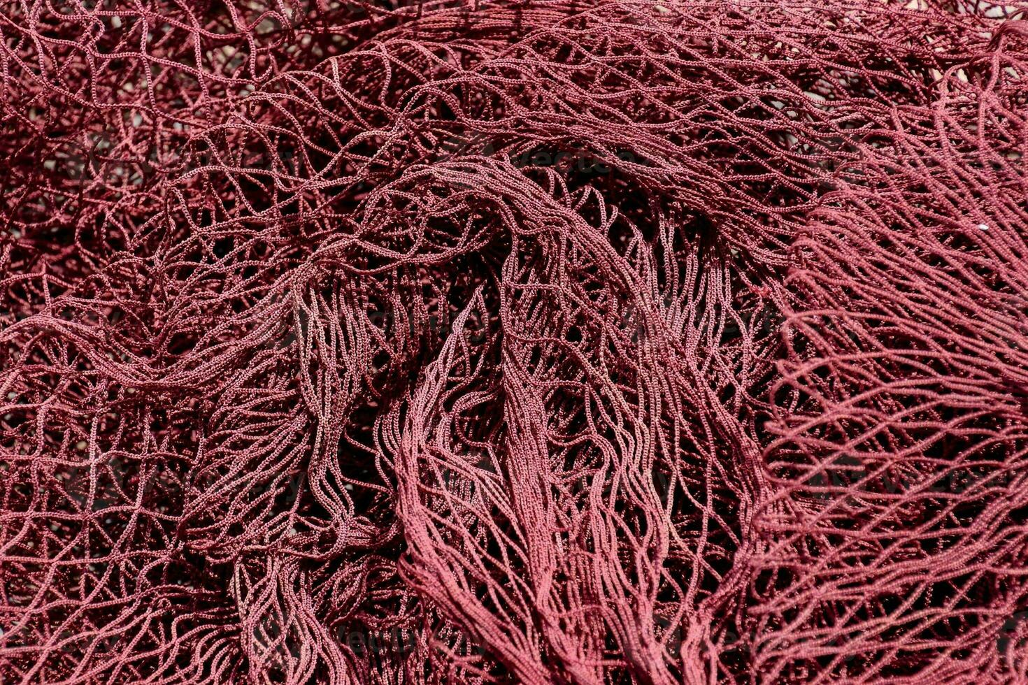 a pile of red netting with a red background photo