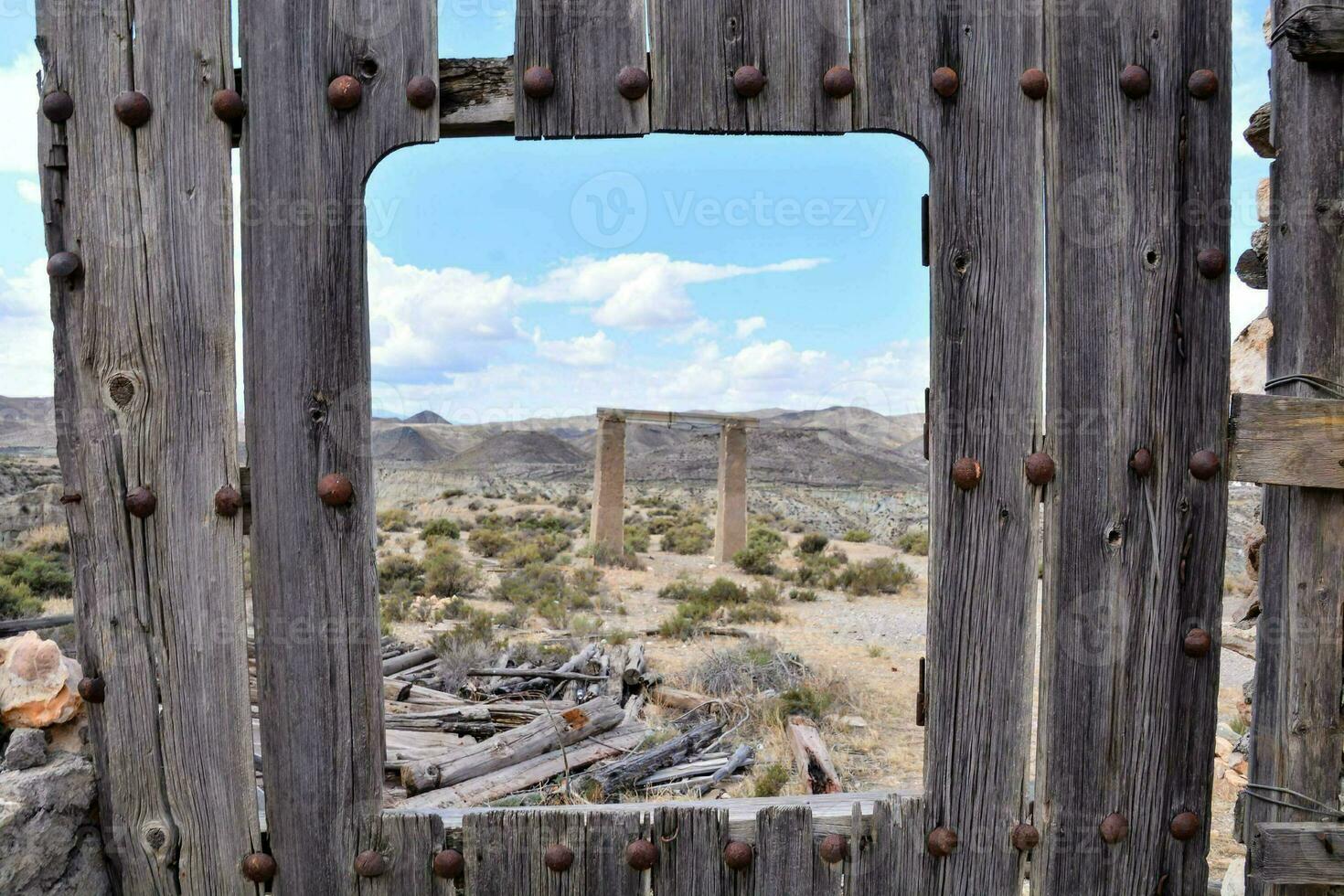 un antiguo de madera puerta en el Desierto con un ver de el montañas foto
