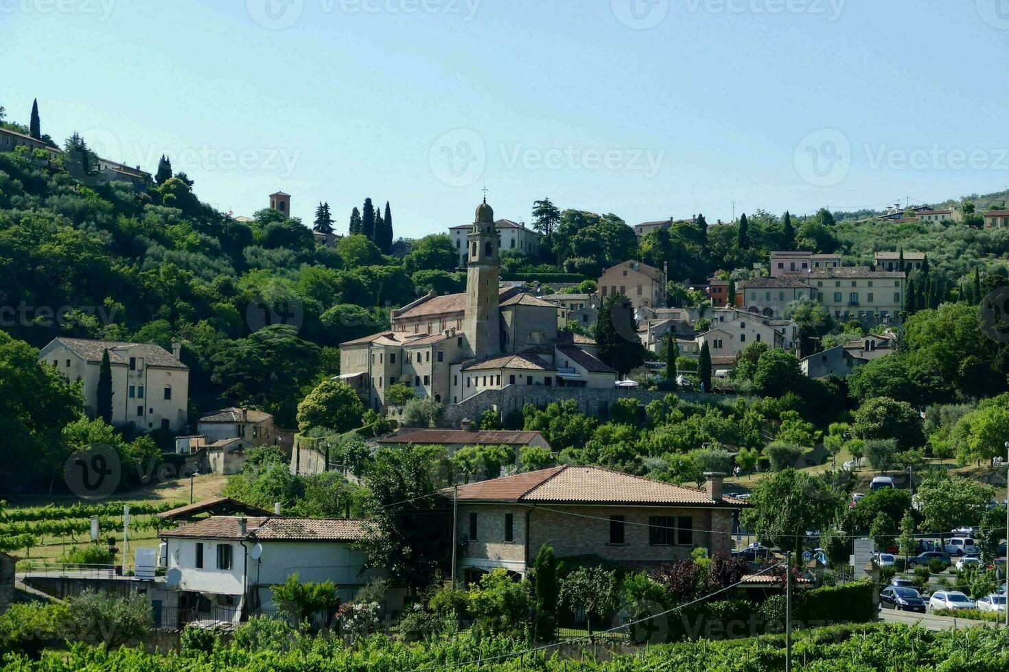 a village with a church on top of a hill photo