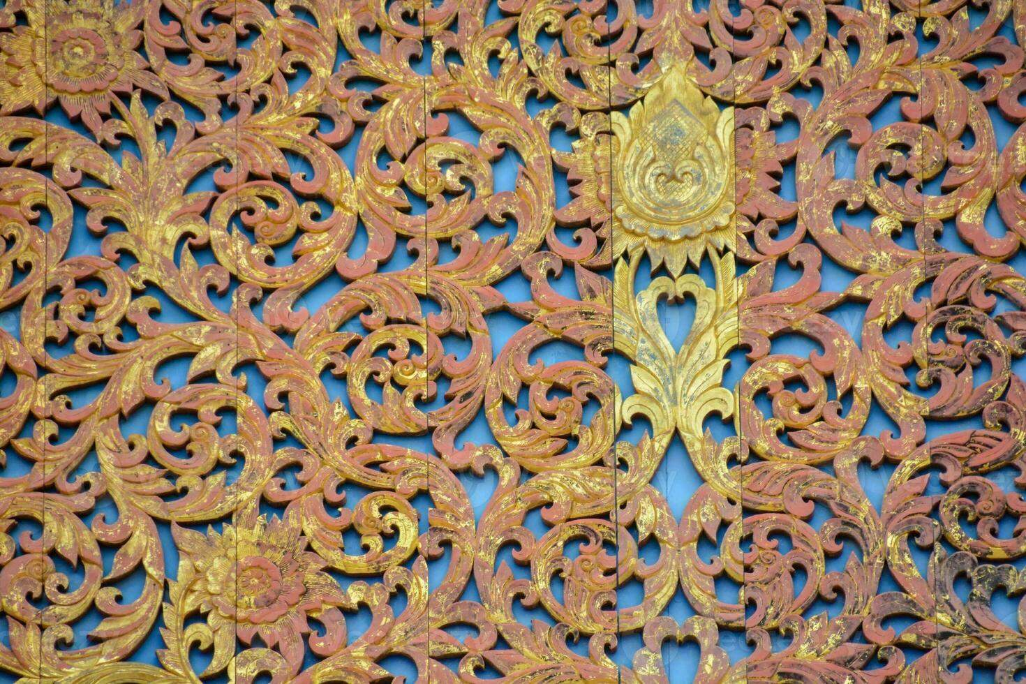 an ornate wooden wall with gold and red designs photo