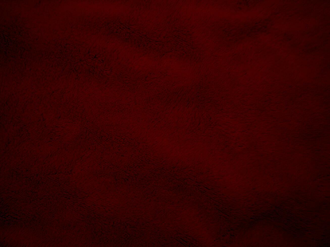 textura de tela de terciopelo rojo utilizada como fondo. fondo de tela roja vacía de material textil suave y liso. hay espacio para el texto. foto