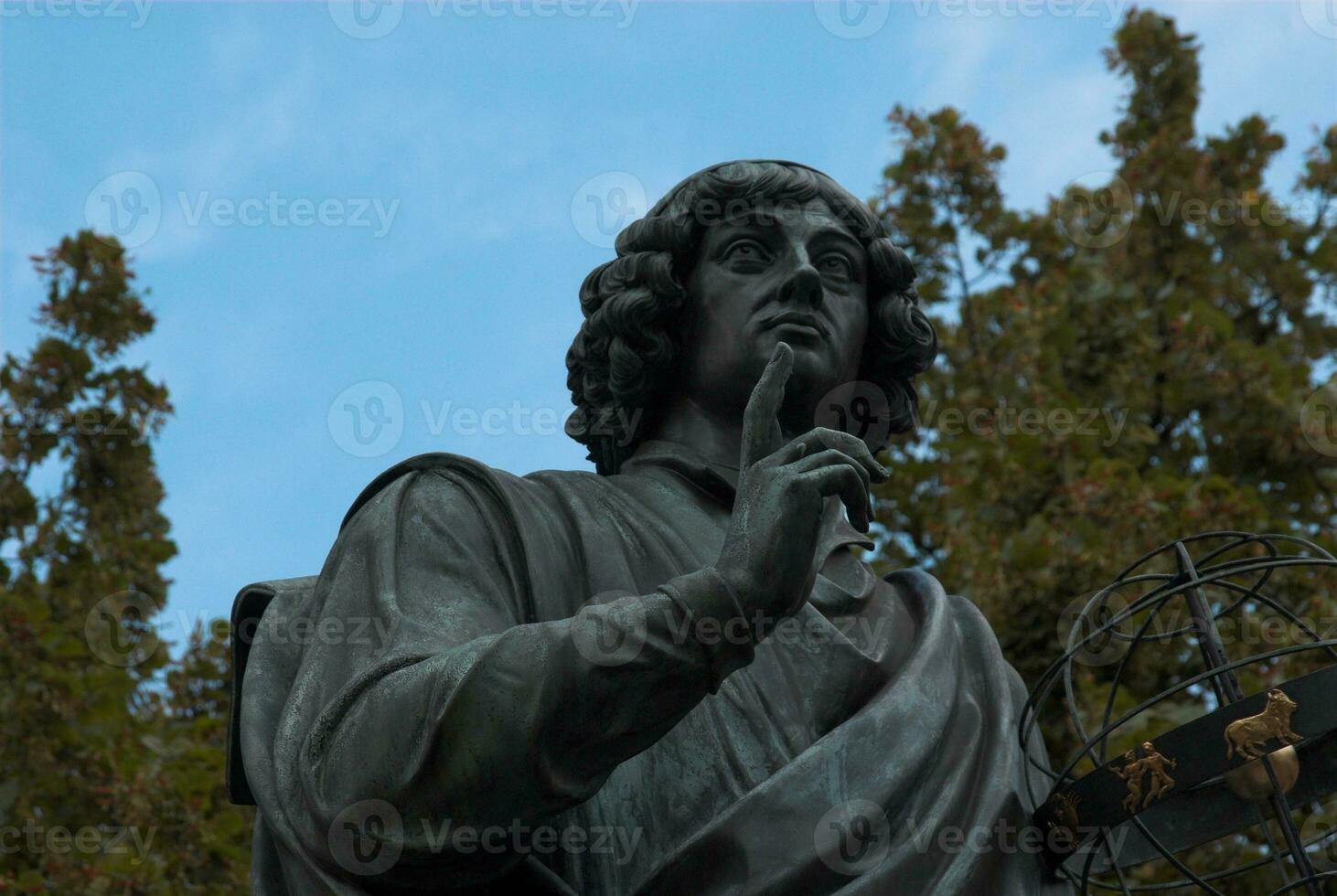 historic monument to astronomer Nicolaus Copernicus in the old city of Torun in Poland on these skies photo