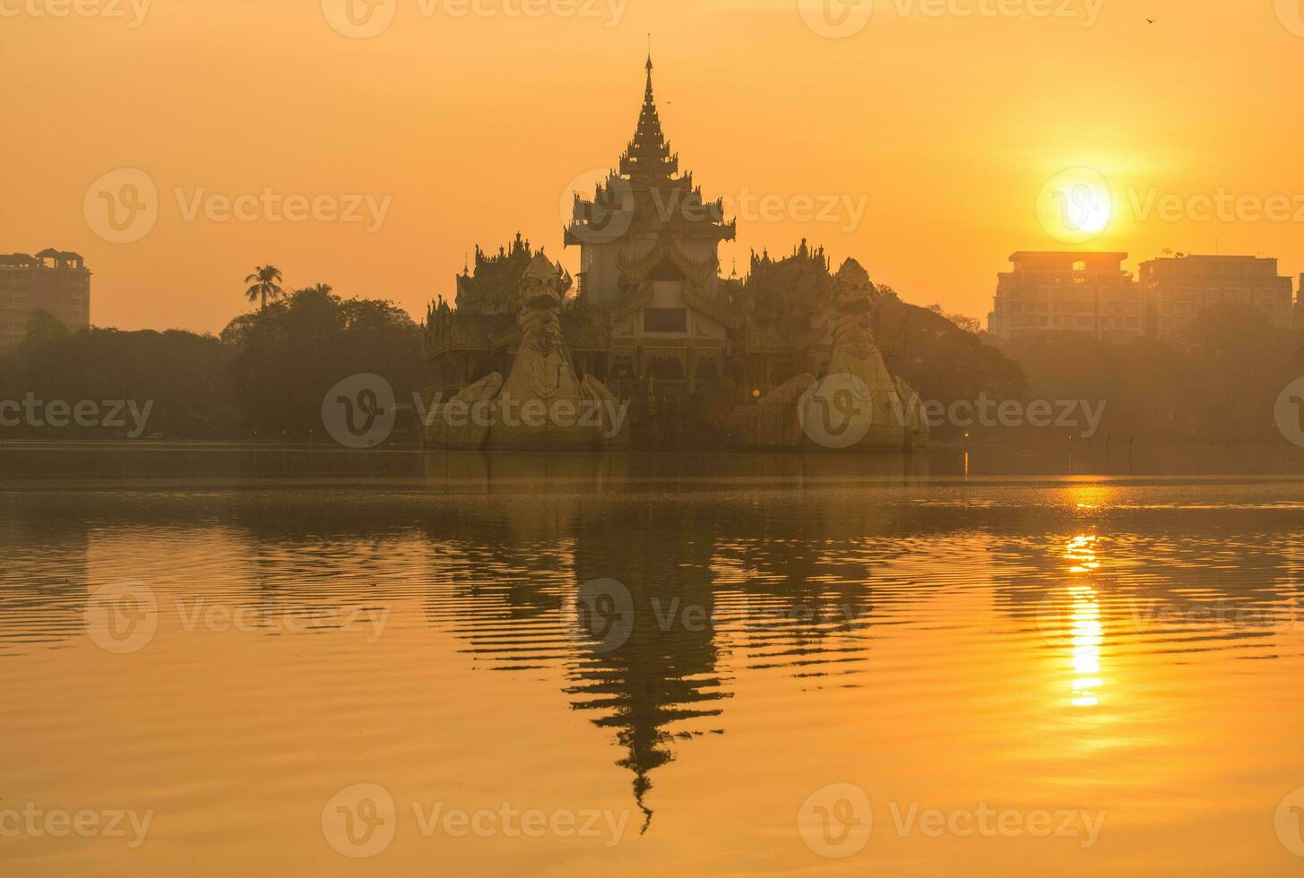 hermoso amanecer sobre el palacio karaweik en el municipio de yangon de myanmar. foto