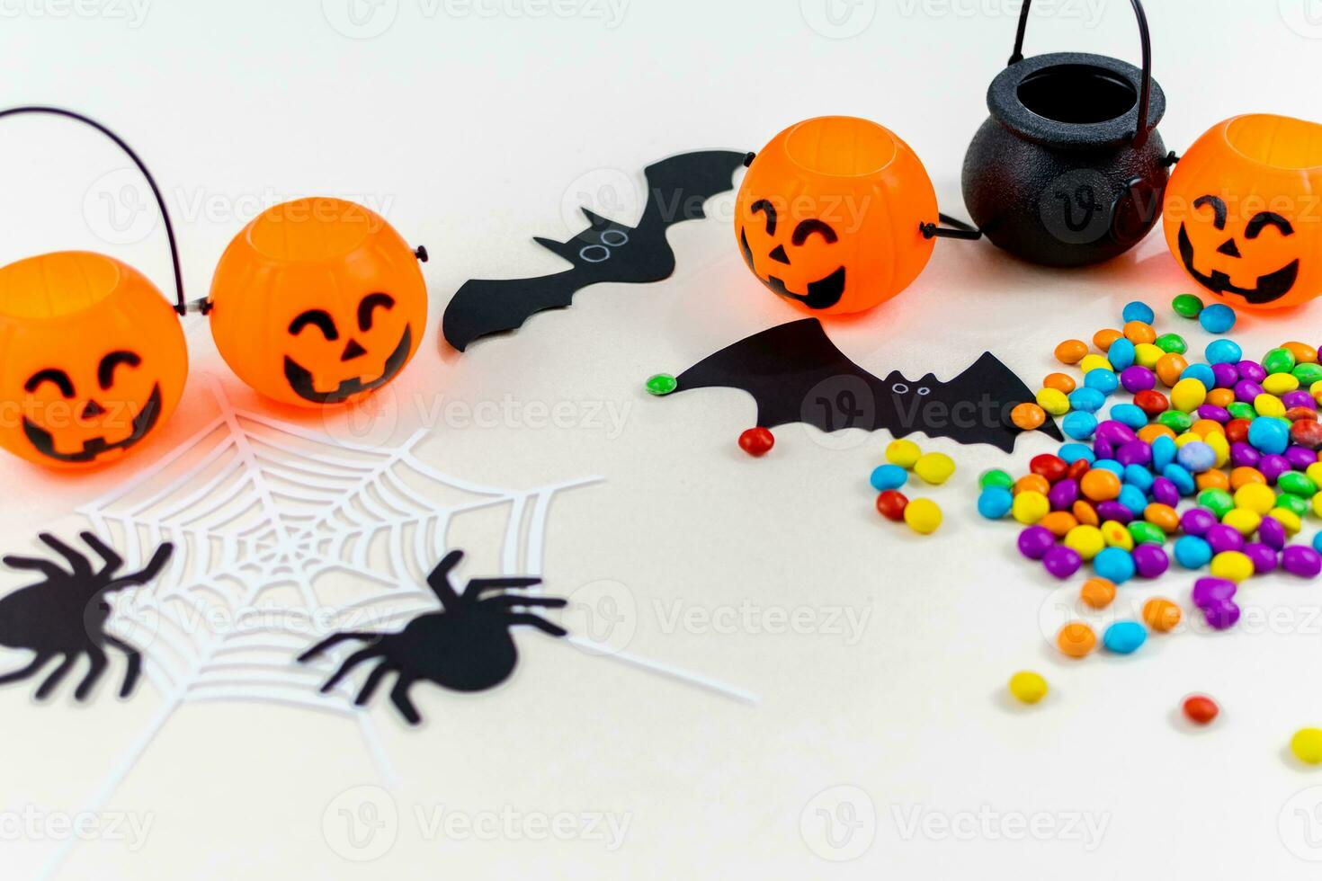 Halloween, pumpkins, bat silhouettes, spider web silhouette and paper spiders, on white background. Selective focus. photo