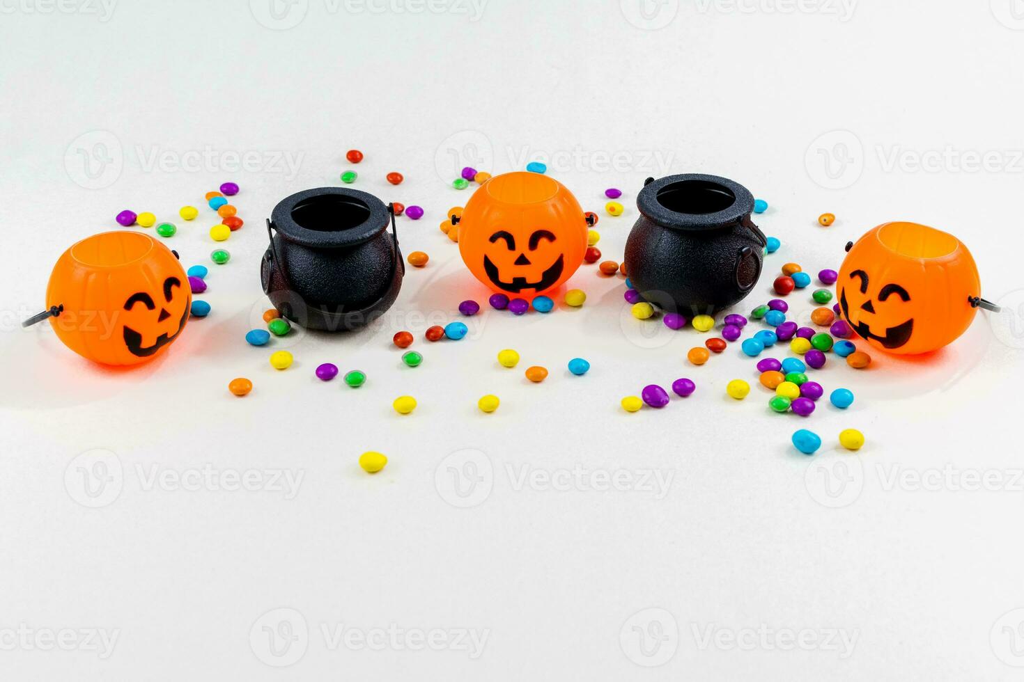 Halloween, pumpkins, colored sprinkles, cauldron, cauldron, on white background. Selective focus. photo