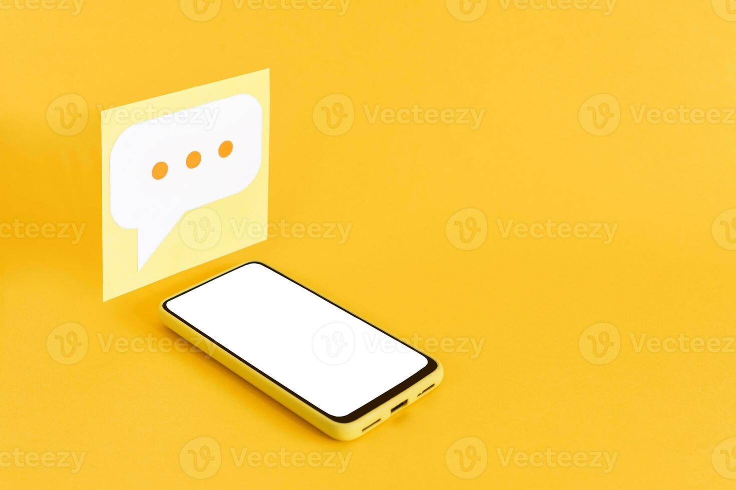 Paper speech bubbles and smart phone with blank screen, on yellow background. Isometric view. photo