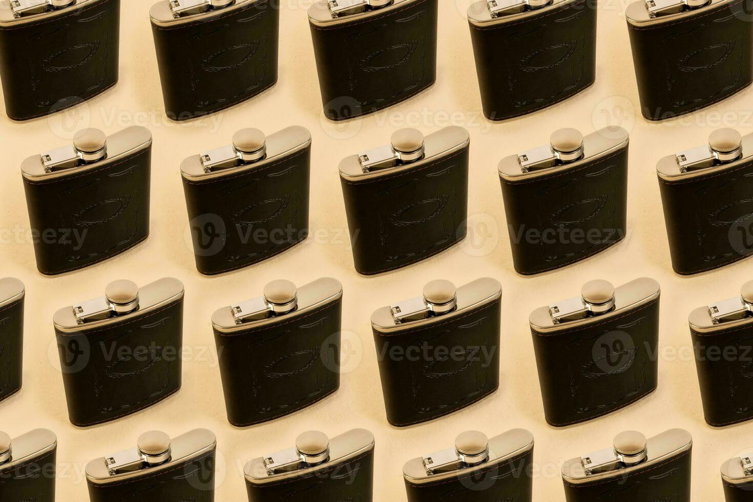 Side view of pattern whiskey flask, hip flask isolated on a beige background photo