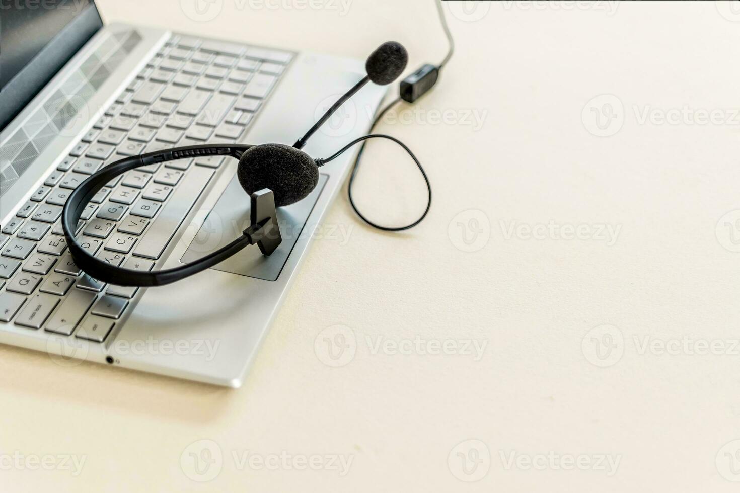 Headset with microphone on keyboard computer laptop, on desktop. Call center support concept. photo