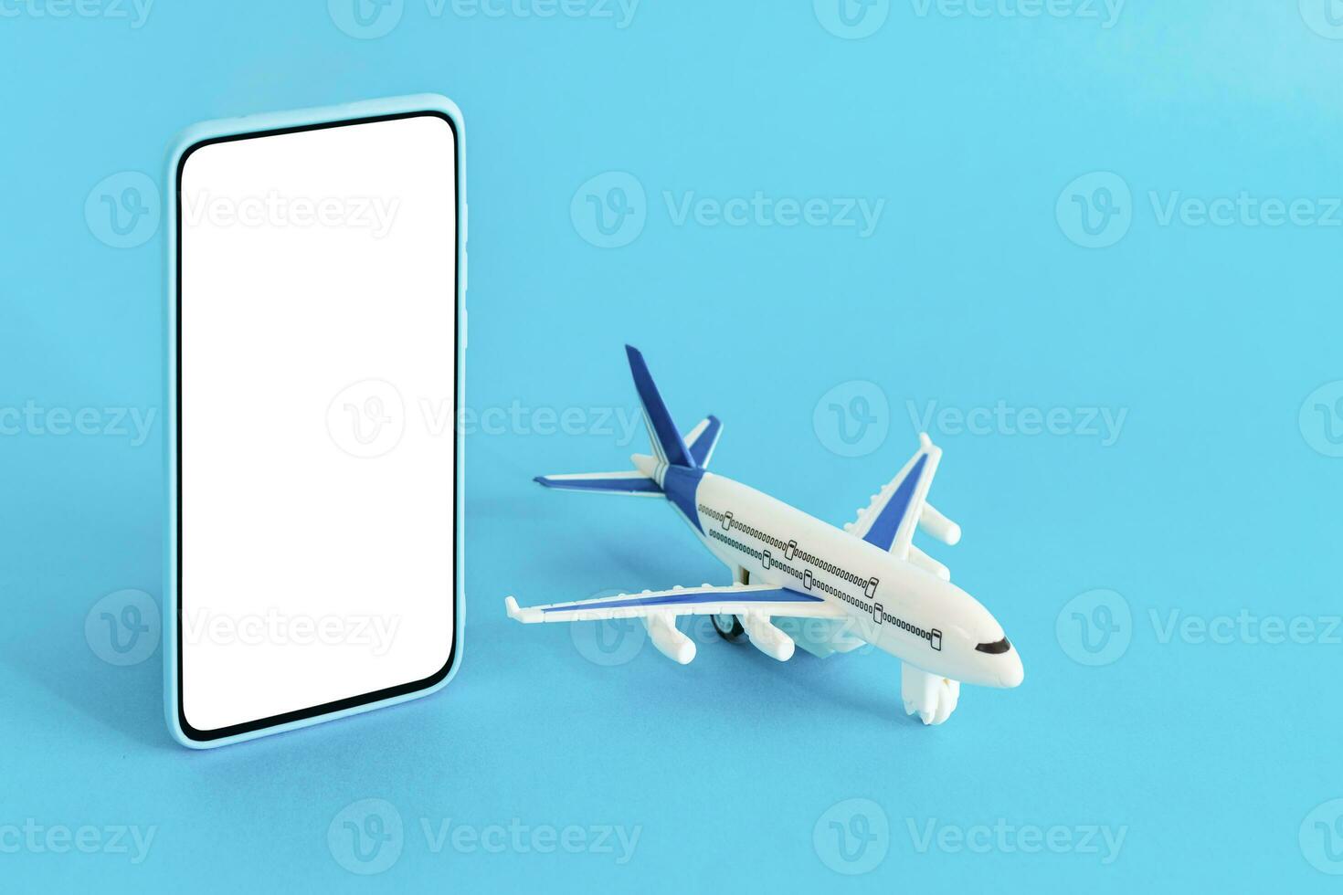 Airplane and smart phone on light blue background. Travel concept. photo