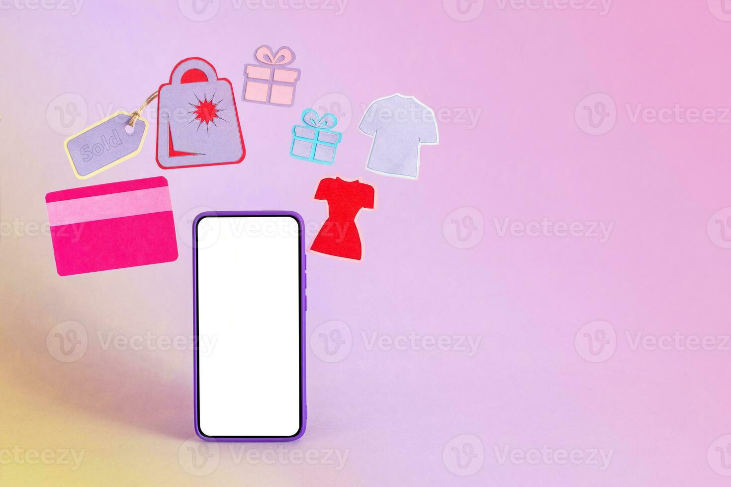 Smart phone surrounded by credit card, shopping bag, clothes and gifts on purple background. photo