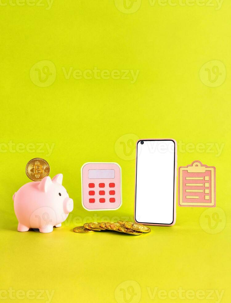 smart phone, piggy bank, calculator, coins, bit coin, on yellow background. Savings concept. photo