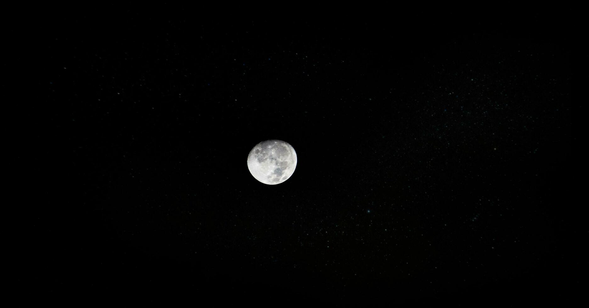 el Luna es visto en el oscuro cielo foto