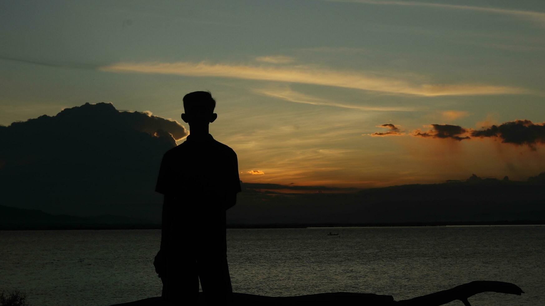 silhouette of man on the lake photo