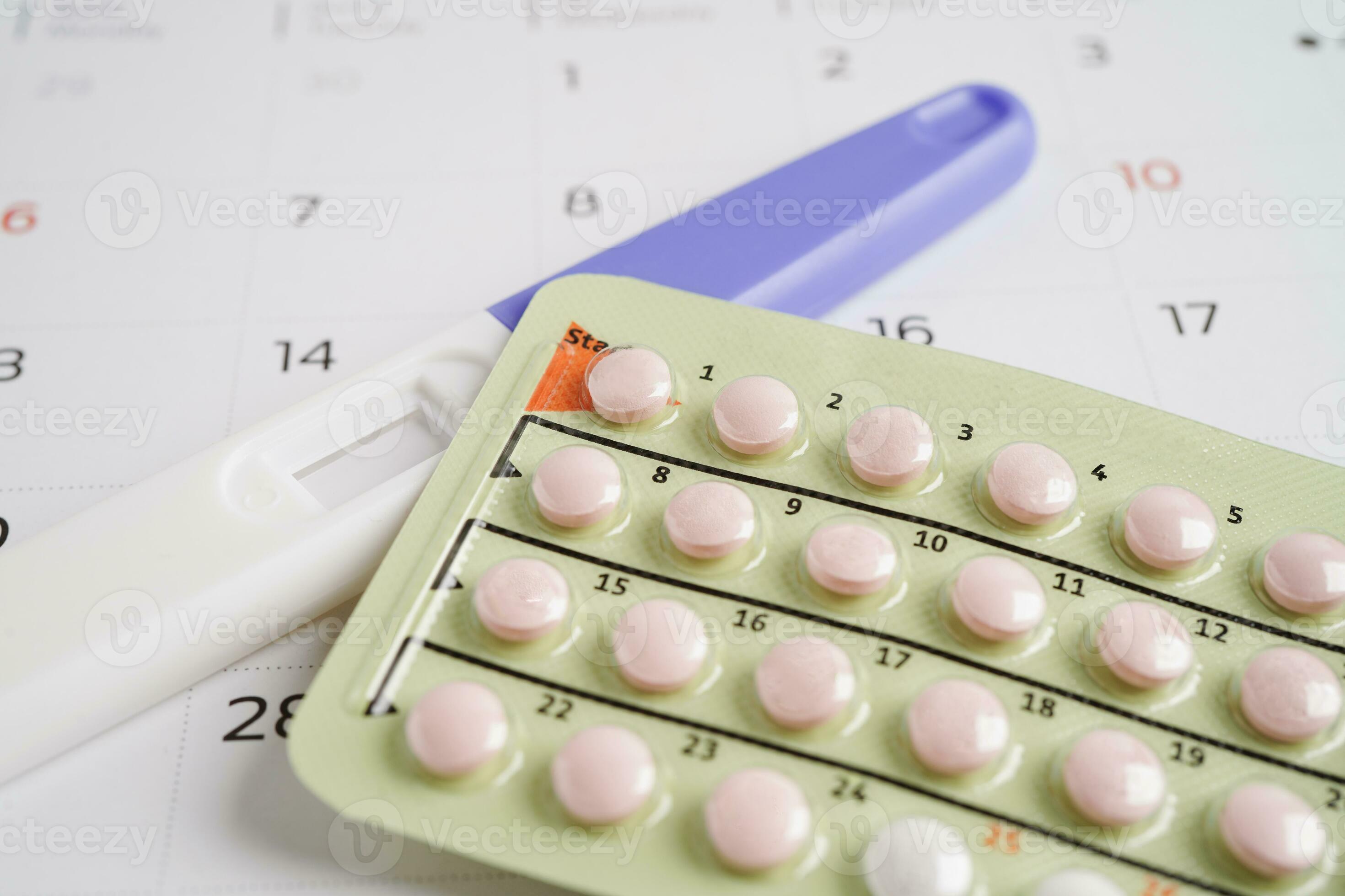 Pregnancy test with birth control pills for female on calendar