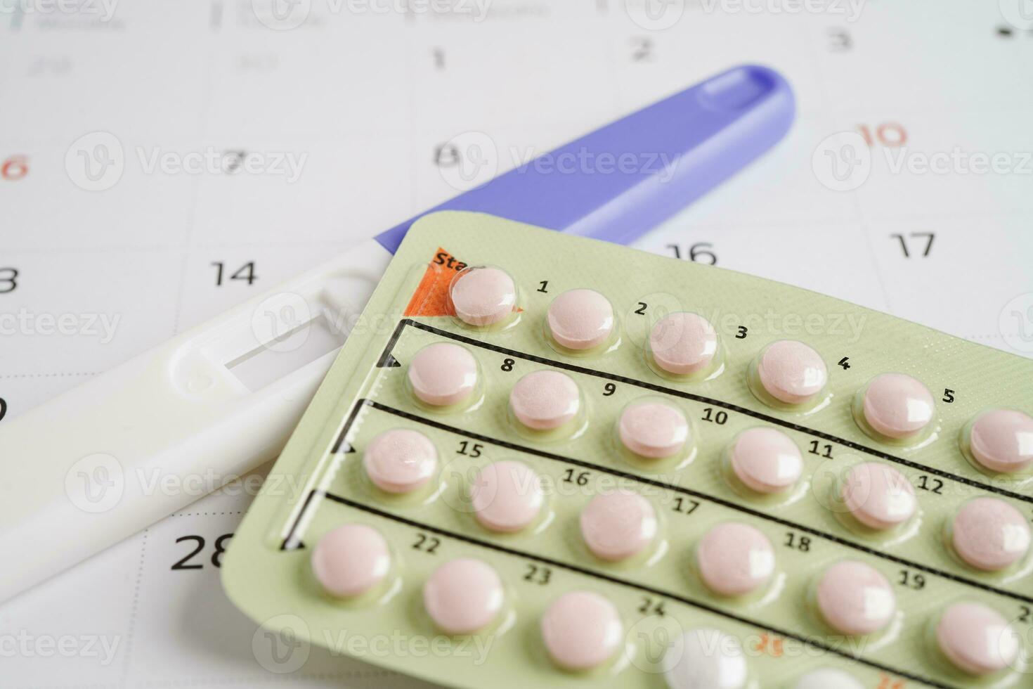 Pregnancy test with birth control pills for female on calendar
