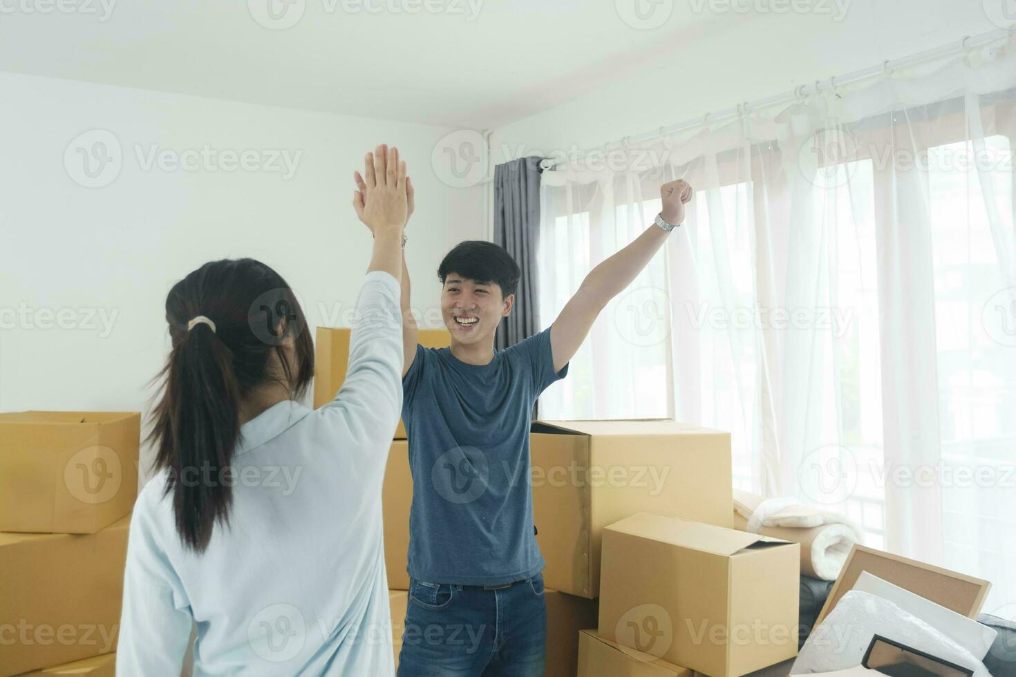 Happy couple with cardboard boxes in new house at moving day. photo