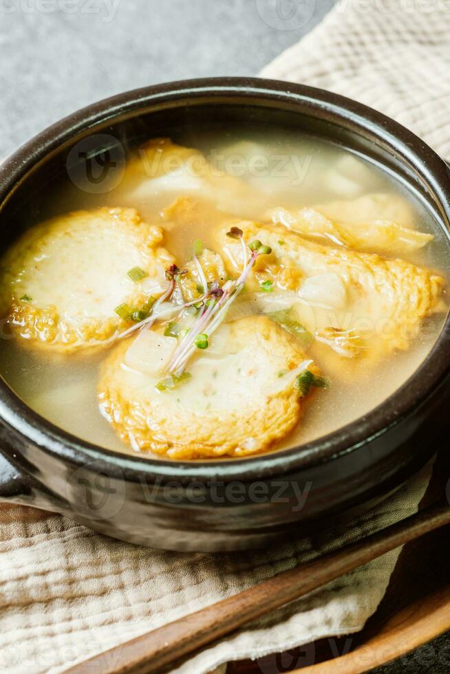 Korean fish cake soup served in a black clay pot photo