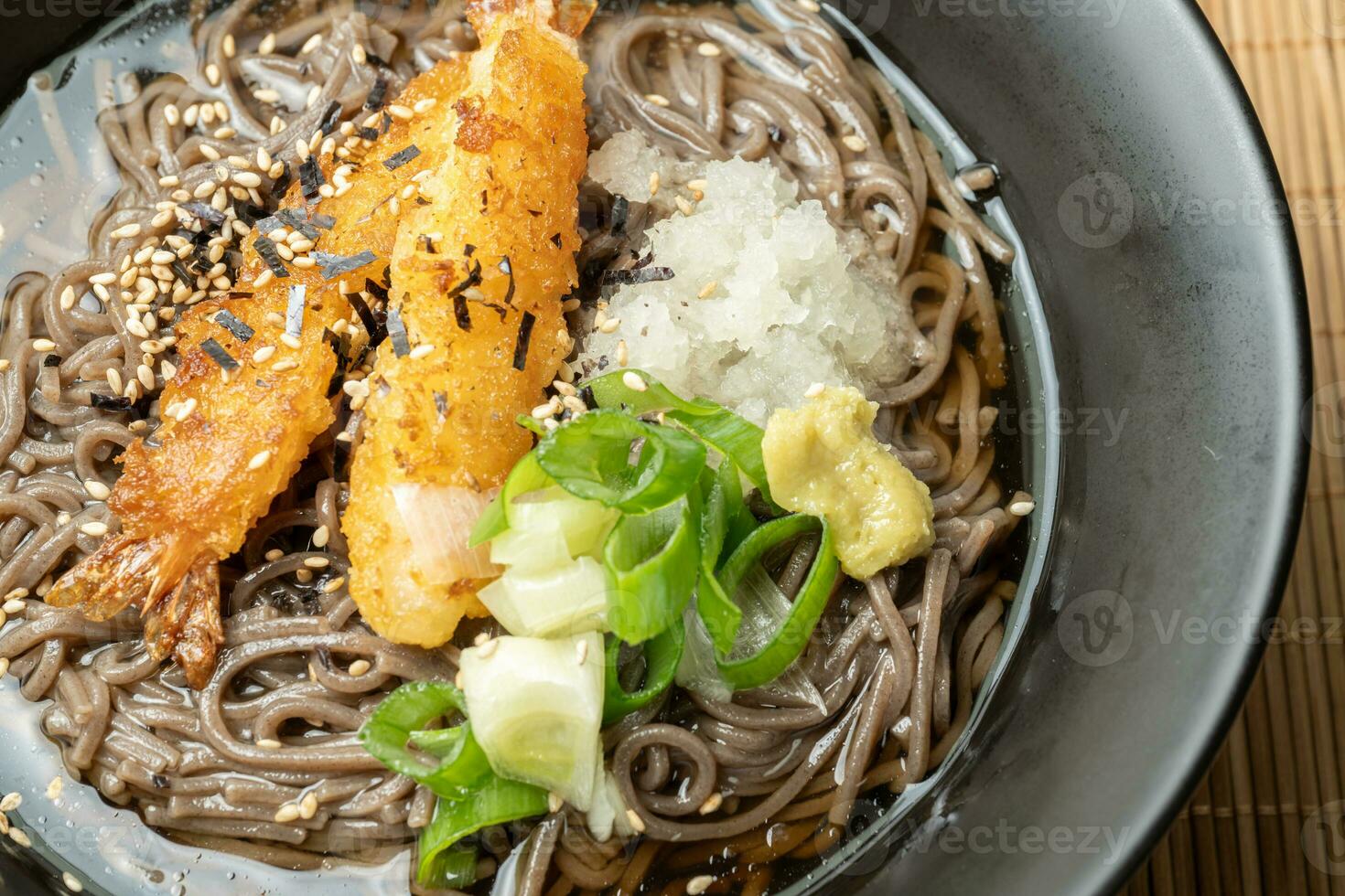 A summer dish of cold wheat noodles with fried shrimp in a black bowl photo