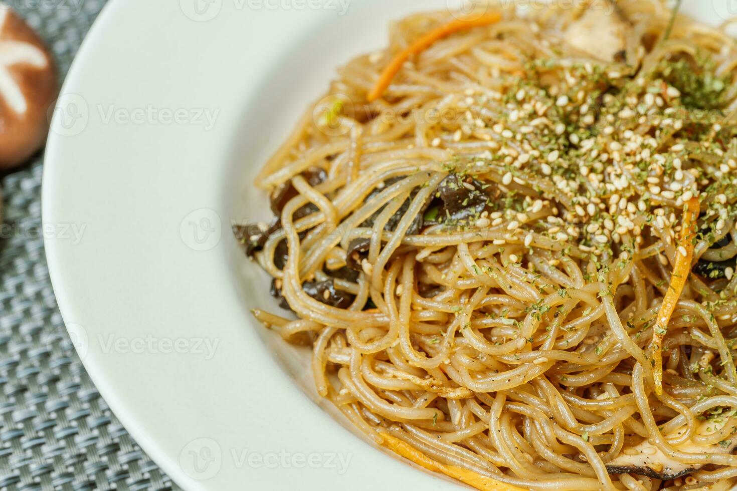 coreano comida japchae servido en un negro plato foto