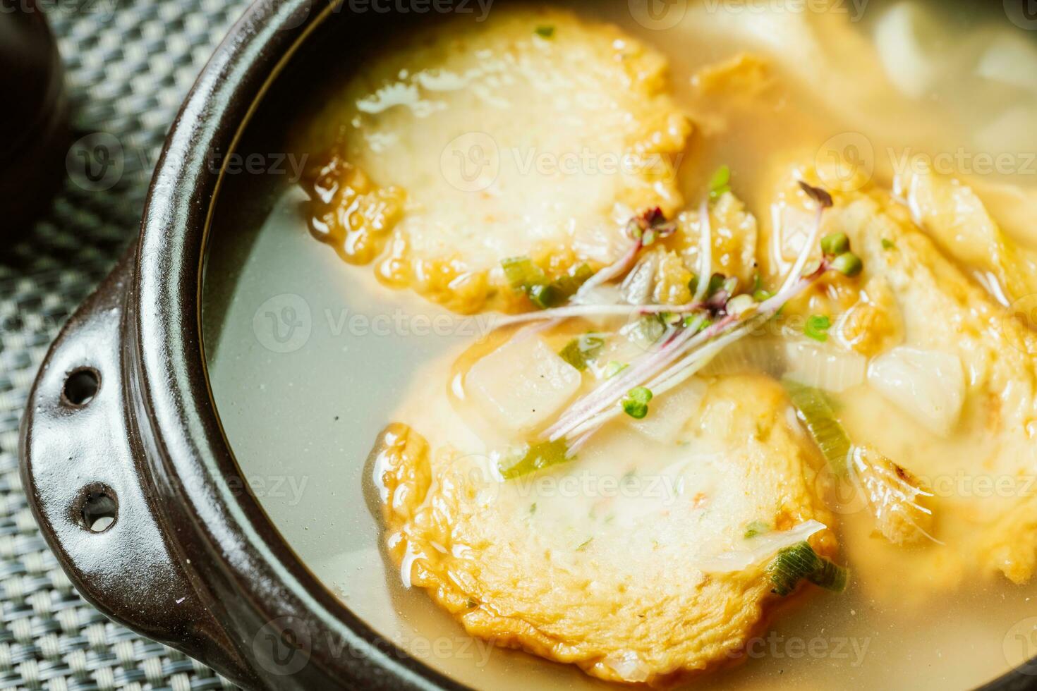 coreano pescado pastel sopa servido en un negro arcilla maceta foto