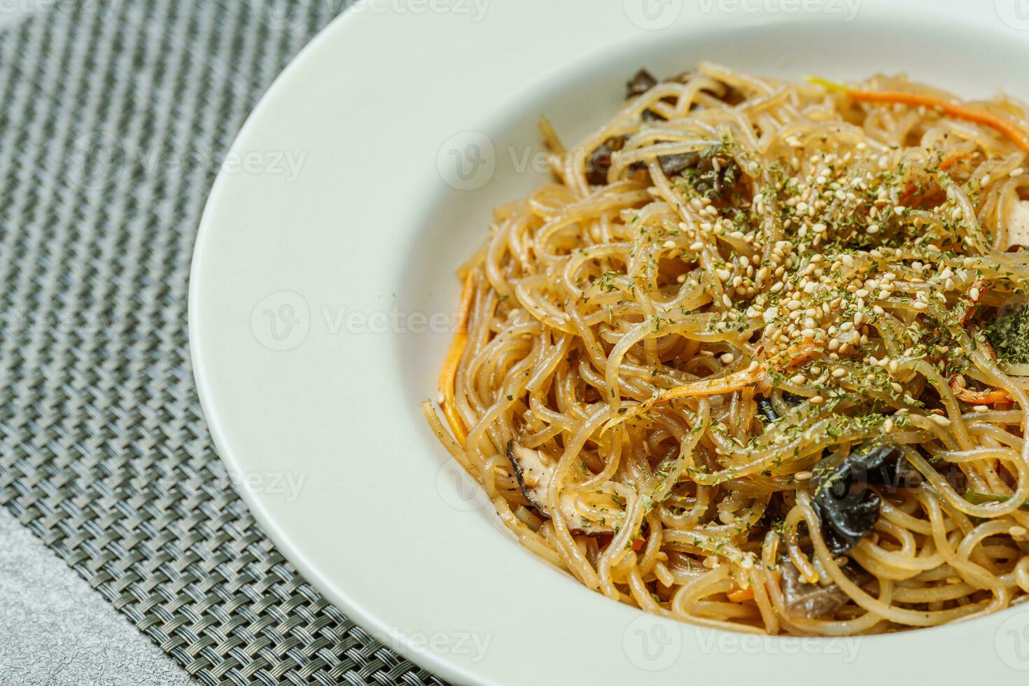 coreano comida japchae servido en un negro plato foto