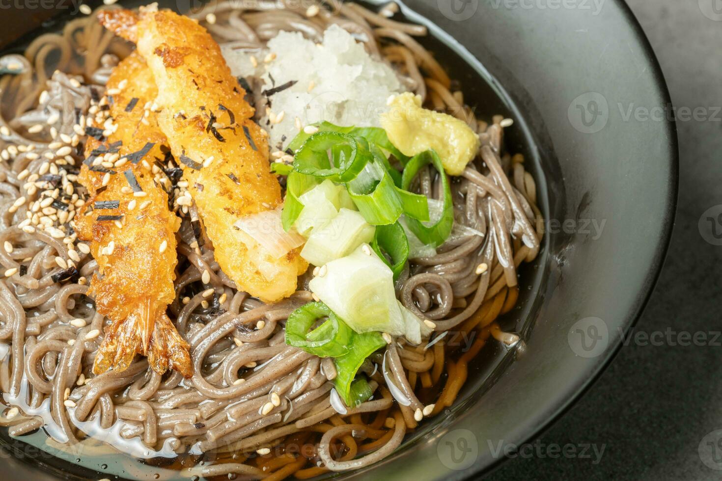 A summer dish of cold wheat noodles with fried shrimp in a black bowl photo