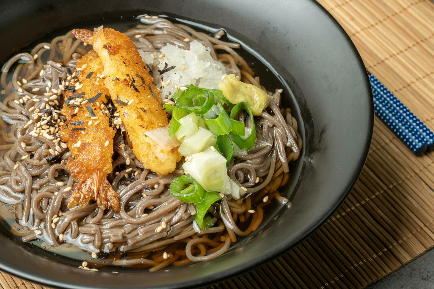 A summer dish of cold wheat noodles with fried shrimp in a black bowl photo