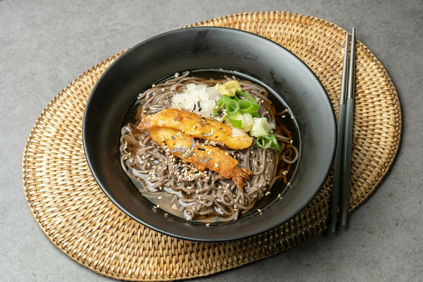A summer dish of cold wheat noodles with fried shrimp in a black bowl photo