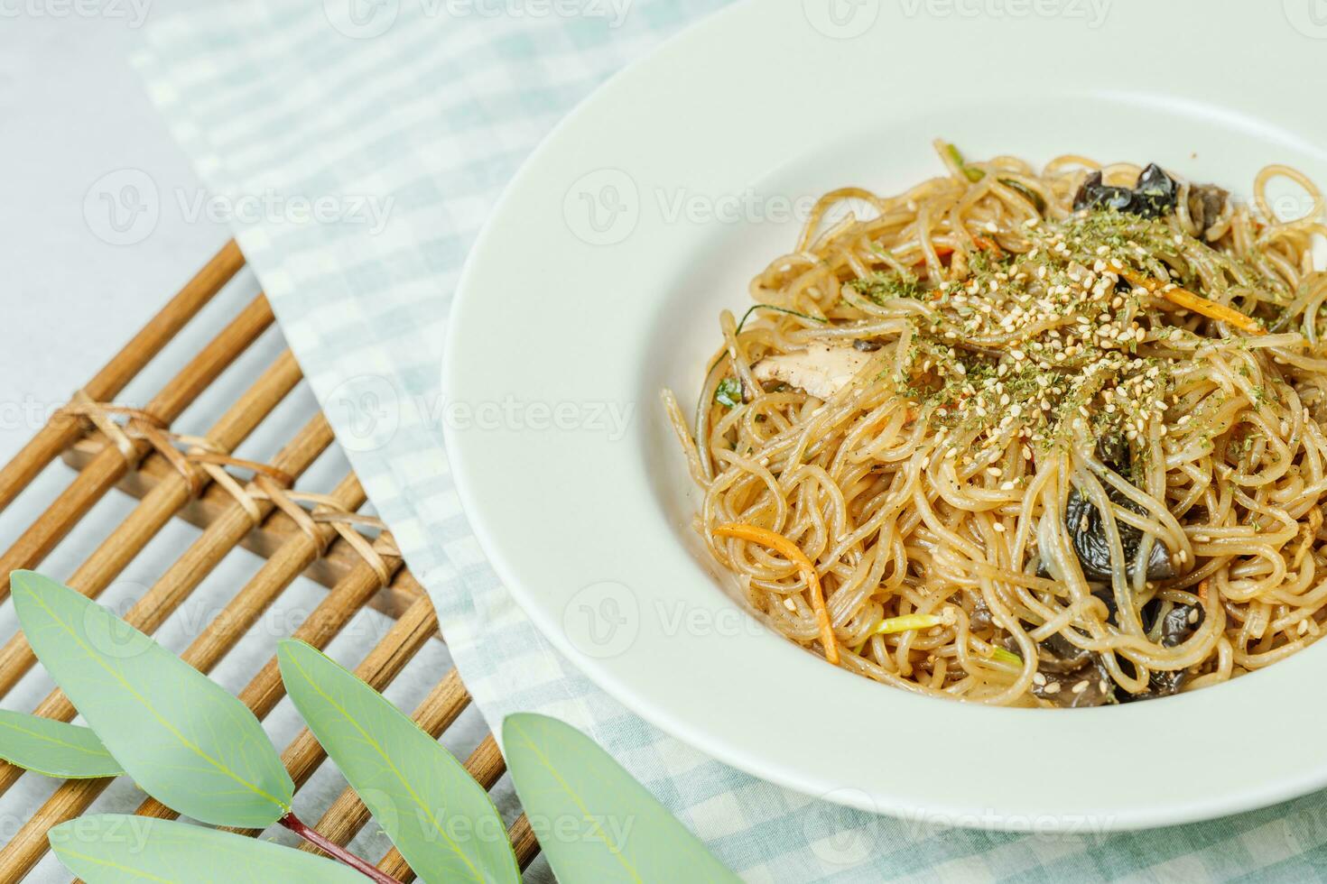 coreano comida japchae servido en un negro plato foto