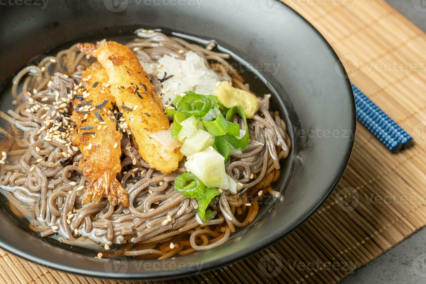 A summer dish of cold wheat noodles with fried shrimp in a black bowl photo